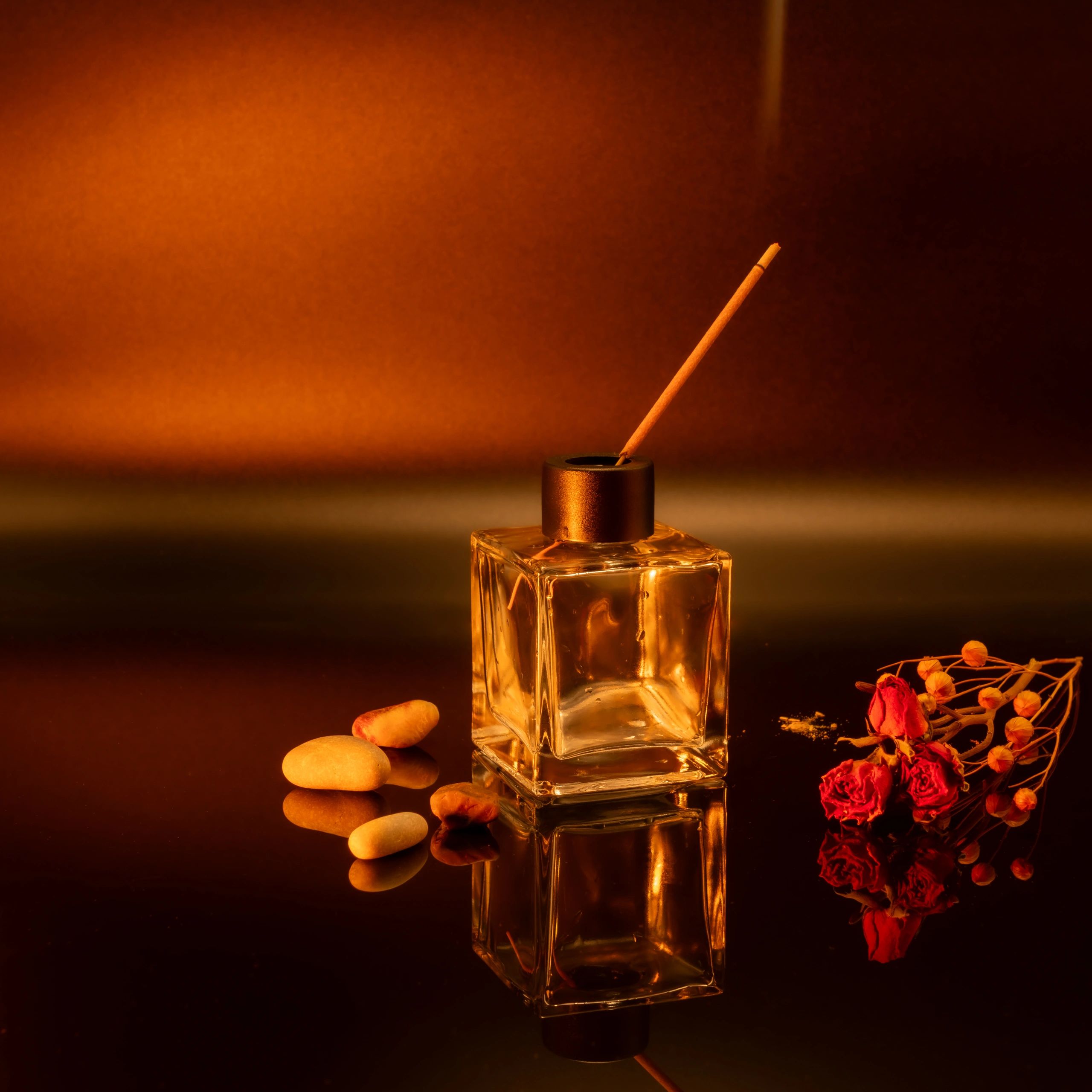 Warm amber home fragrance arrangement with roses